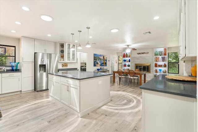 kitchen featuring stainless steel fridge, decorative light fixtures, white cabinetry, and ceiling fan