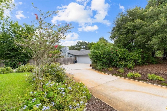 view of front facade featuring a garage, fence, and concrete driveway