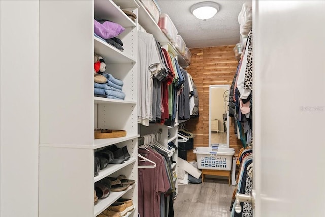 walk in closet with wood finished floors