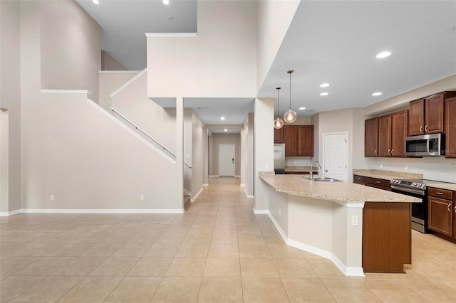 kitchen featuring stainless steel appliances, a center island with sink, sink, a breakfast bar, and hanging light fixtures