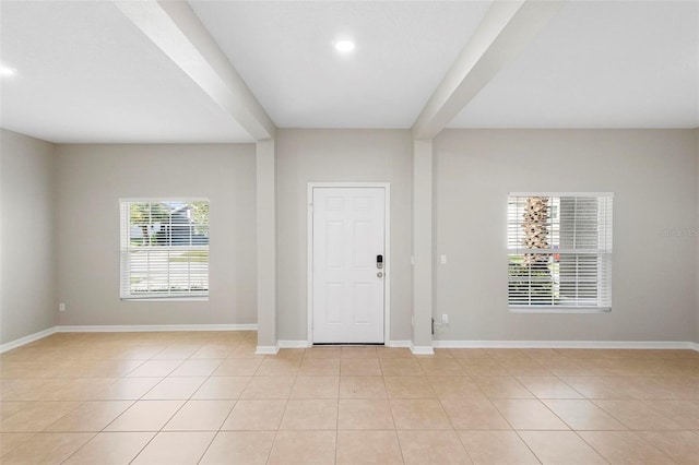 foyer entrance featuring light tile patterned flooring and beam ceiling