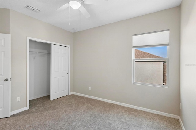 unfurnished bedroom with a closet, light colored carpet, and ceiling fan