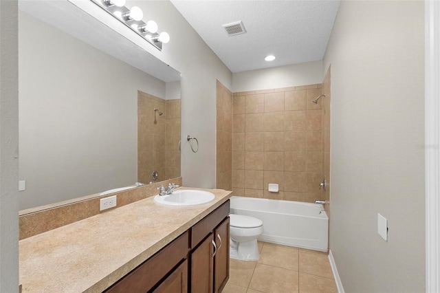 full bathroom with toilet, tile patterned flooring, tiled shower / bath, a textured ceiling, and vanity