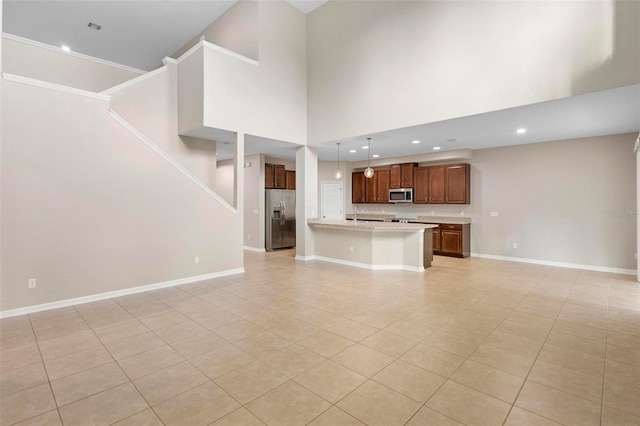 unfurnished living room featuring a towering ceiling and light tile patterned flooring