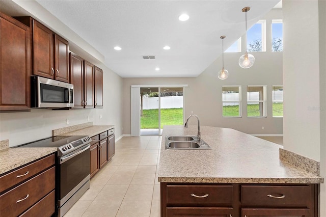 kitchen featuring stainless steel appliances, sink, decorative light fixtures, and plenty of natural light