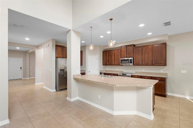 kitchen featuring light stone counters, light tile patterned flooring, stainless steel appliances, hanging light fixtures, and sink