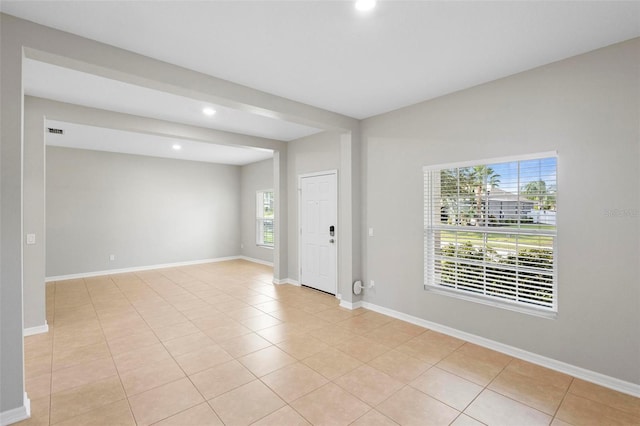 spare room with light tile patterned floors and a healthy amount of sunlight