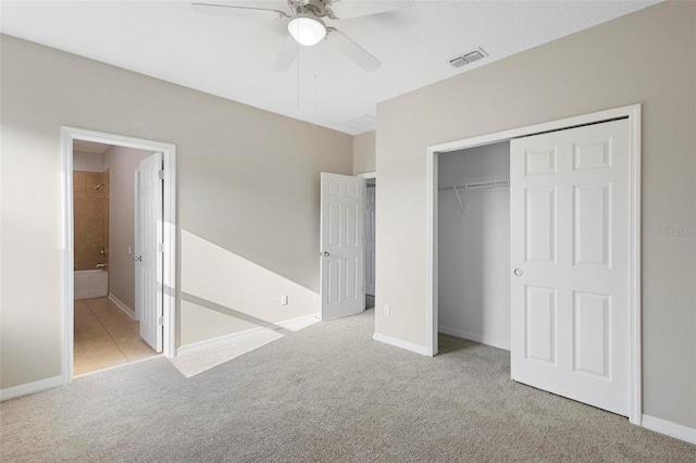 unfurnished bedroom featuring light colored carpet, ceiling fan, connected bathroom, and a closet