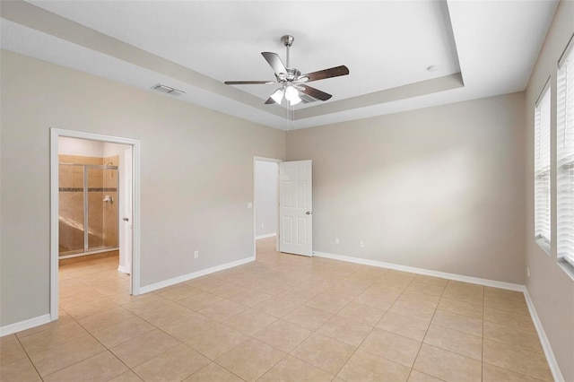 unfurnished room featuring light tile patterned flooring, ceiling fan, and a raised ceiling