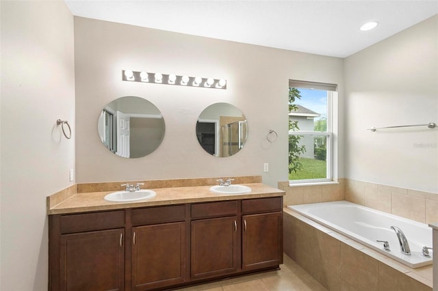 bathroom with vanity, tile patterned floors, and a relaxing tiled tub