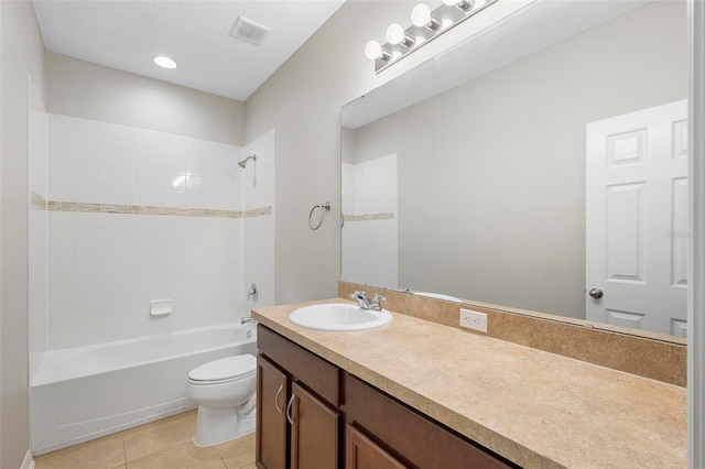 full bathroom featuring tile patterned flooring, vanity, tiled shower / bath combo, and toilet