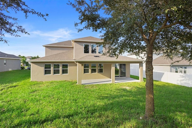 back of house with a lawn and a patio area