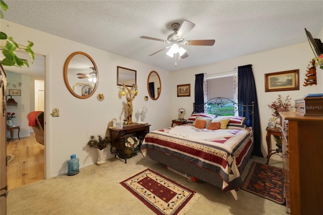 carpeted bedroom featuring ceiling fan and a textured ceiling