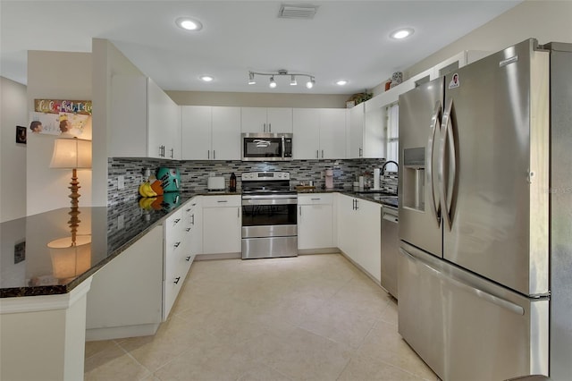 kitchen featuring white cabinets, appliances with stainless steel finishes, and decorative backsplash