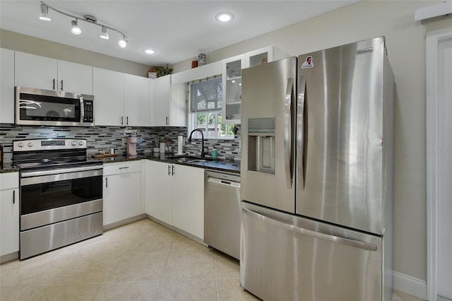 kitchen with stainless steel appliances, white cabinetry, tasteful backsplash, and sink