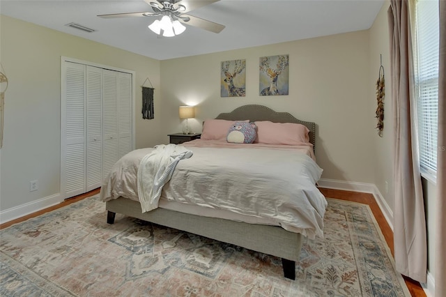 bedroom with hardwood / wood-style flooring, ceiling fan, and a closet