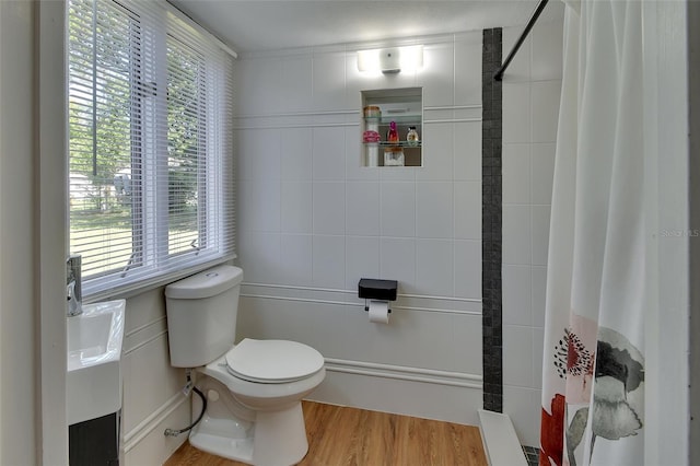 bathroom featuring a shower with shower curtain, wood-type flooring, tile walls, and toilet