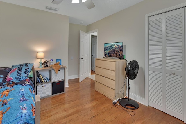 bedroom with a closet, light wood-type flooring, and ceiling fan