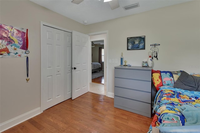 bedroom featuring light wood-type flooring, ceiling fan, and a closet