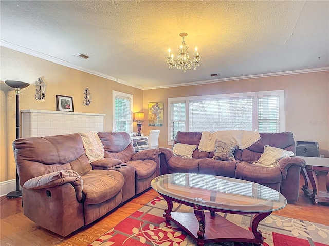 living room with ornamental molding, light hardwood / wood-style floors, an inviting chandelier, and a textured ceiling