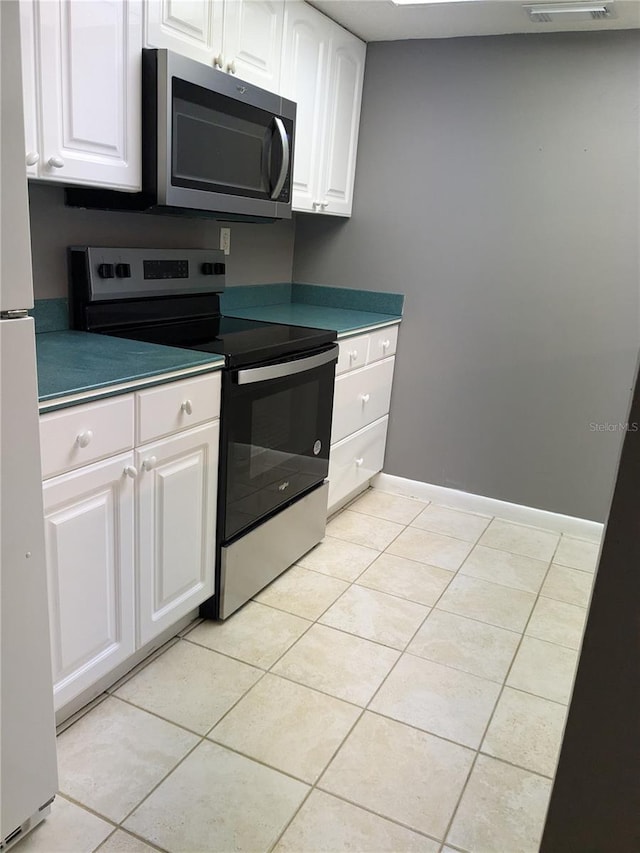 kitchen featuring white cabinetry, light tile patterned floors, and stainless steel appliances