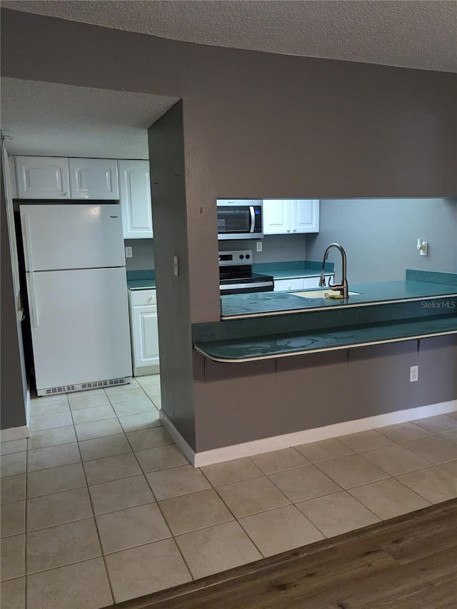 kitchen with white cabinets, a textured ceiling, appliances with stainless steel finishes, and sink