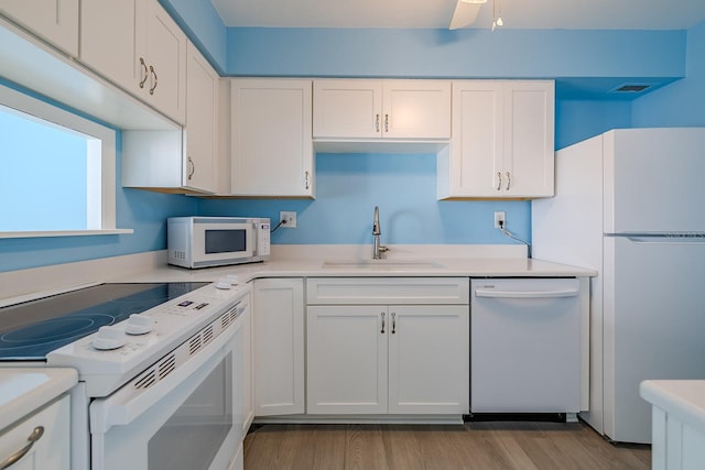 kitchen featuring white appliances, sink, and white cabinets