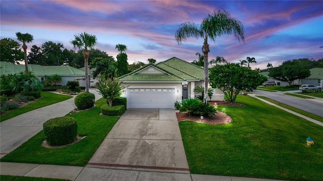 view of front of house with a garage and a yard