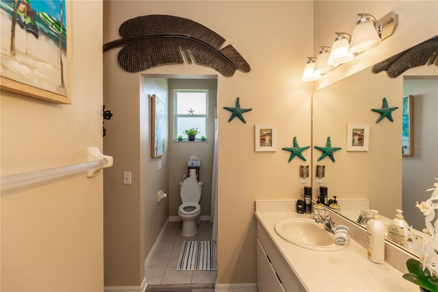 bathroom featuring vanity, tile patterned flooring, and toilet