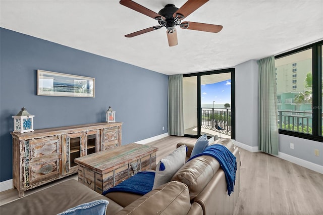 living room featuring light hardwood / wood-style floors, floor to ceiling windows, and ceiling fan