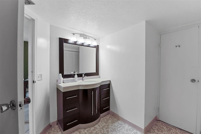 bathroom featuring a textured ceiling and vanity