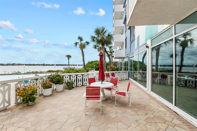 view of patio featuring a water view and a balcony