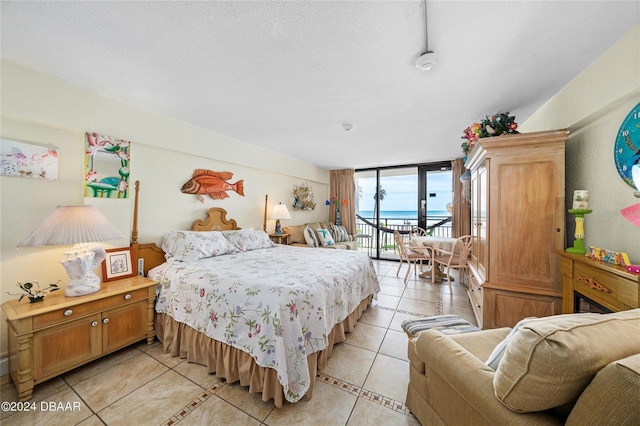 bedroom featuring a textured ceiling, access to exterior, and light tile patterned floors