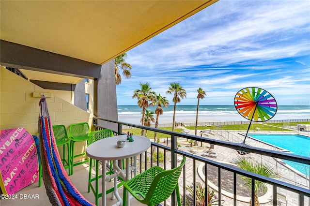 balcony with a water view and a view of the beach