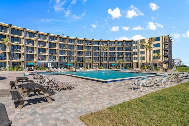 view of pool with a patio and a yard