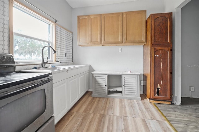 kitchen featuring light wood-type flooring, black range with electric stovetop, and sink