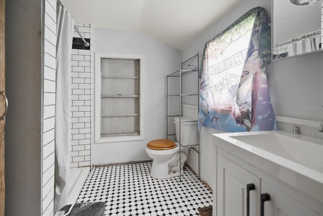 bathroom featuring a shower with shower curtain, built in features, toilet, and sink