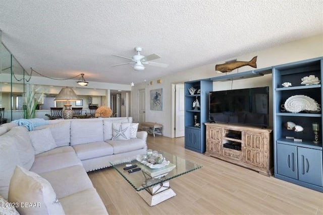 living room with wood-type flooring, a textured ceiling, and ceiling fan