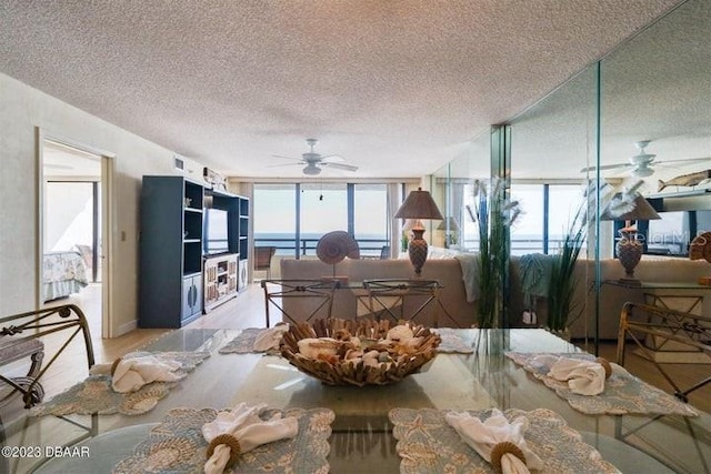 dining area featuring a textured ceiling, a wall of windows, and ceiling fan