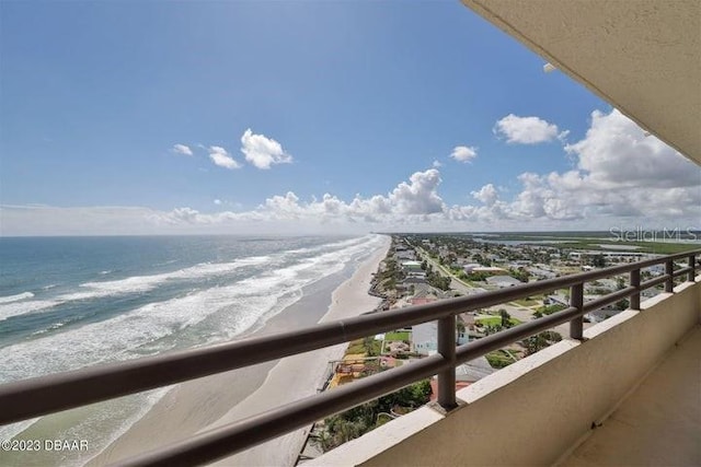 balcony featuring a view of the beach and a water view