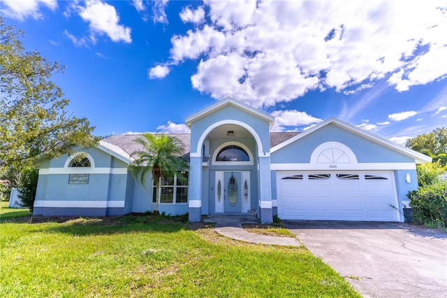 single story home featuring a front lawn and a garage