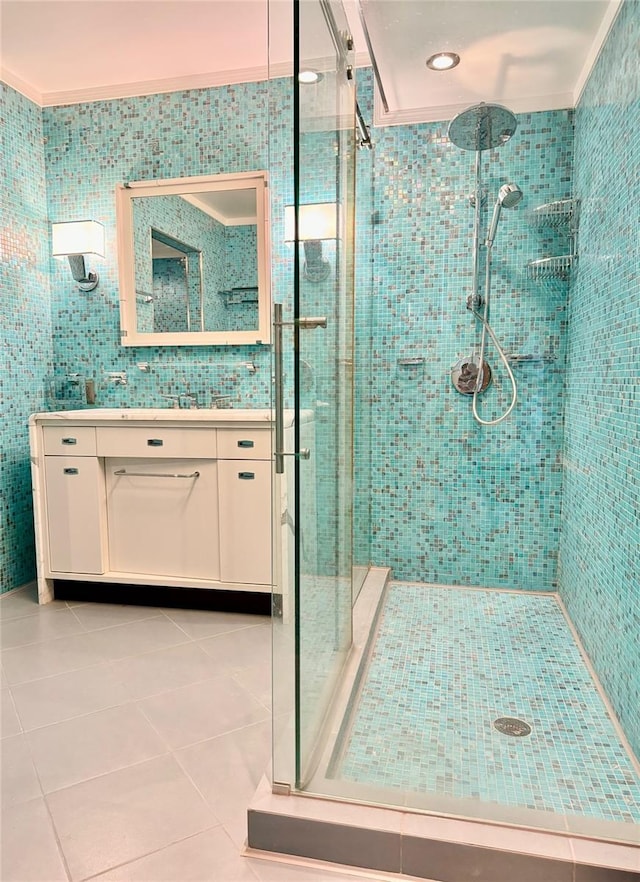 bathroom with vanity, ornamental molding, walk in shower, tile walls, and tile patterned flooring