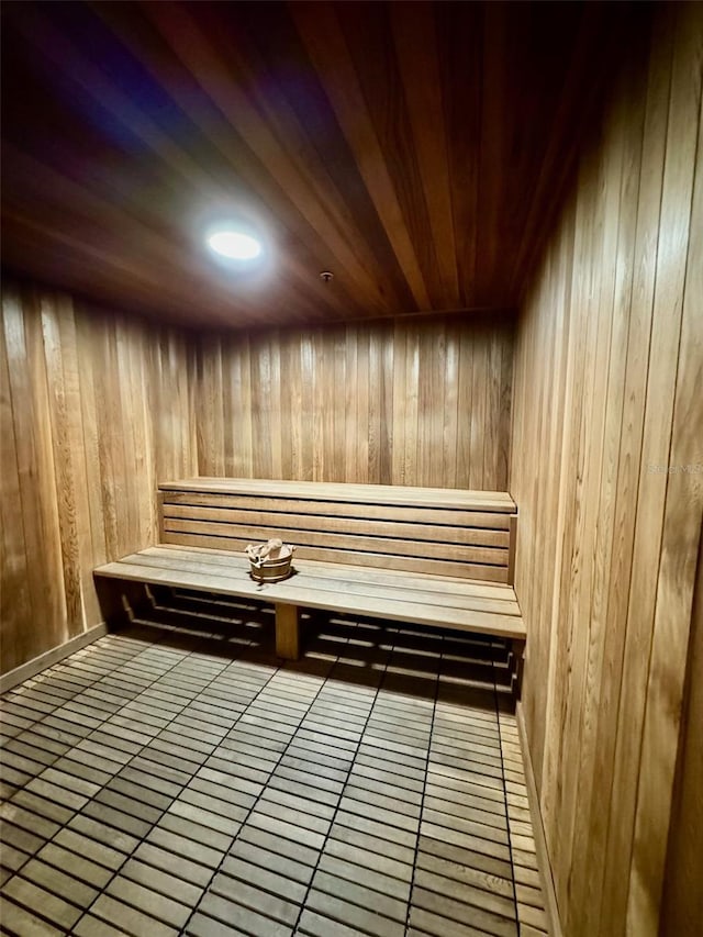 view of sauna featuring wood walls, tile patterned flooring, and wooden ceiling