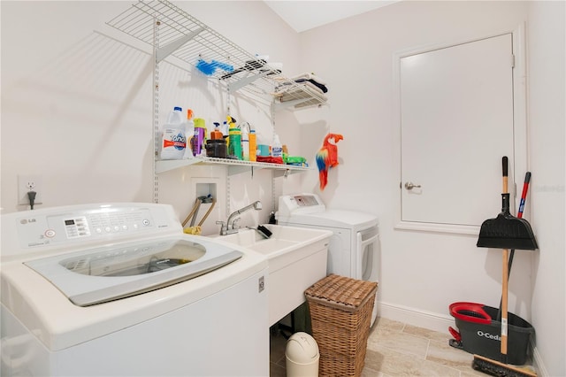 washroom with sink and washing machine and clothes dryer