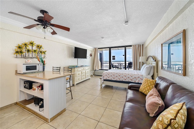 tiled bedroom with access to outside, ceiling fan, expansive windows, and a textured ceiling