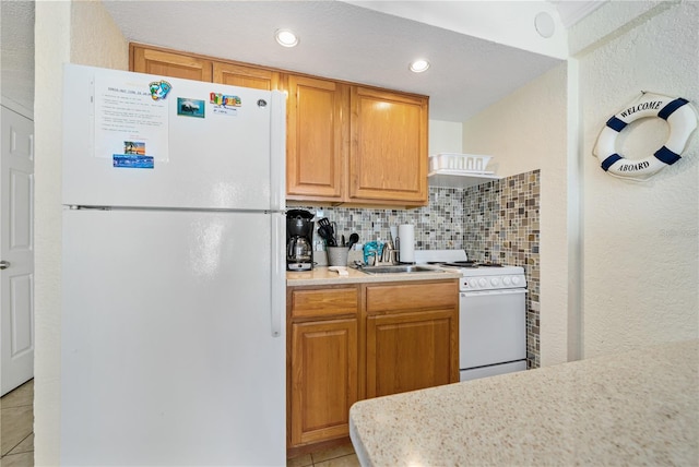 kitchen with tasteful backsplash, sink, light tile patterned flooring, and white appliances