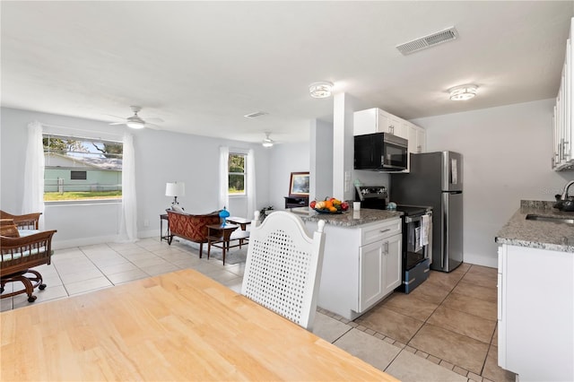 kitchen with stainless steel appliances, white cabinets, a wealth of natural light, and sink