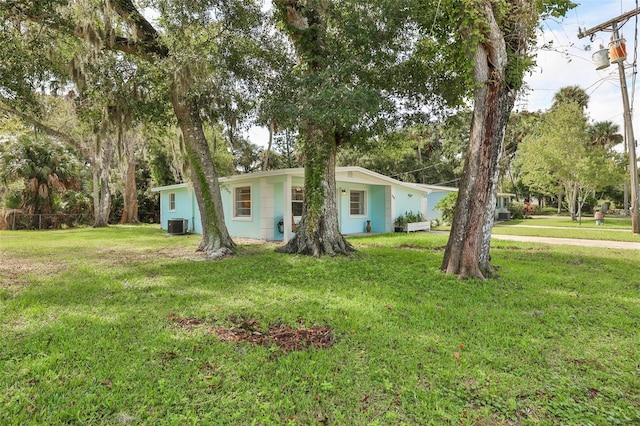 view of front facade featuring central AC unit and a front yard