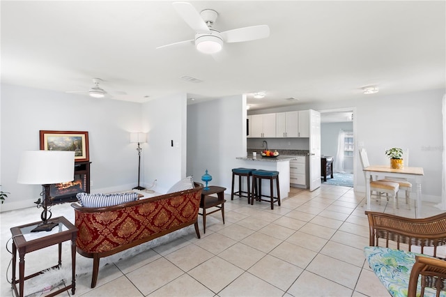 living room with ceiling fan and light tile patterned floors