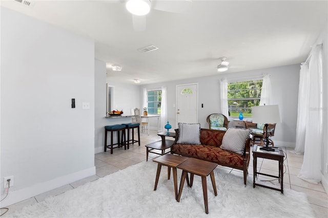 living room featuring ceiling fan, light tile patterned floors, and a wealth of natural light